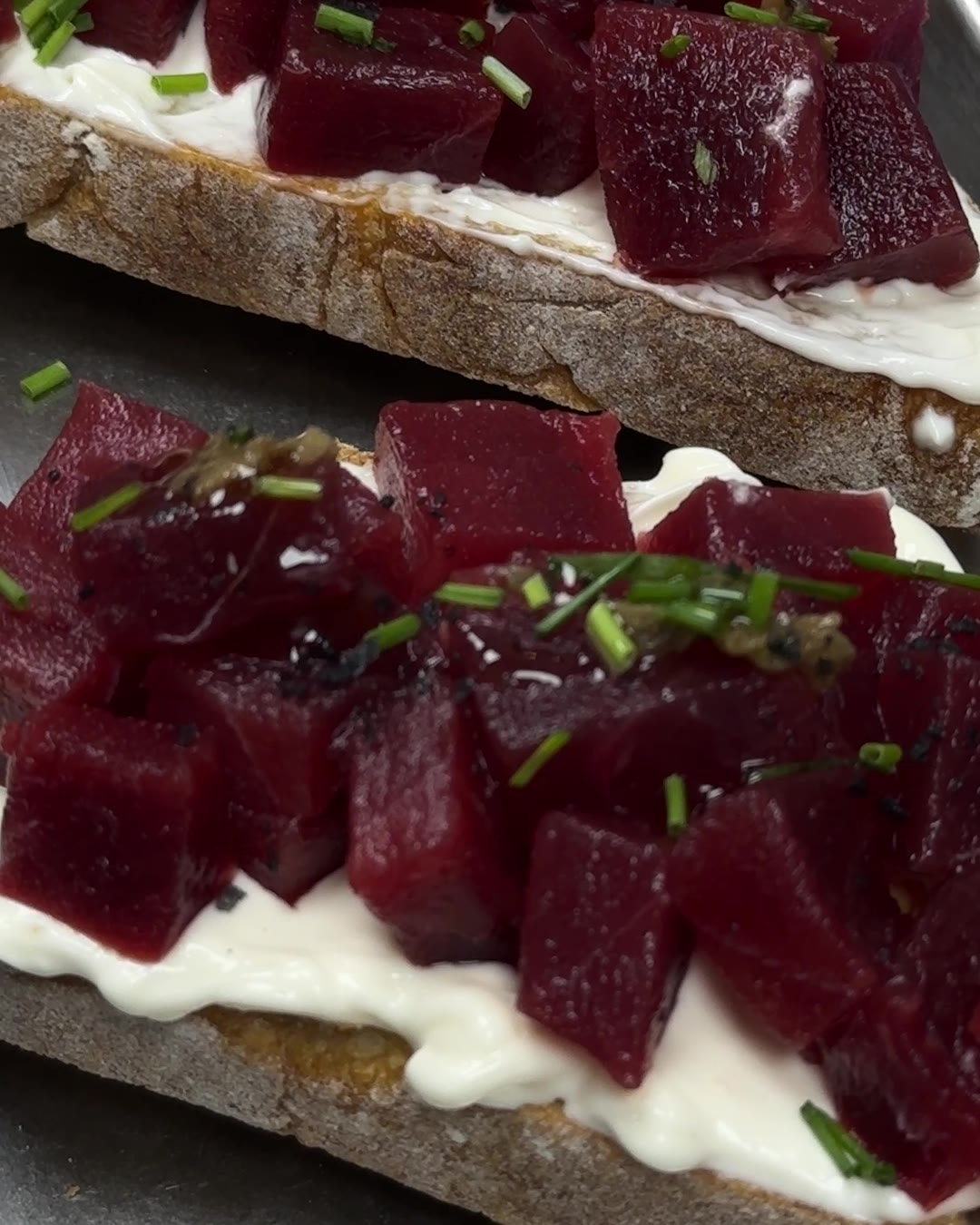 Detalle de la tosta de atún rojo de almadraba: atún en dados sobre mayonesa de sésamo, con cebollino