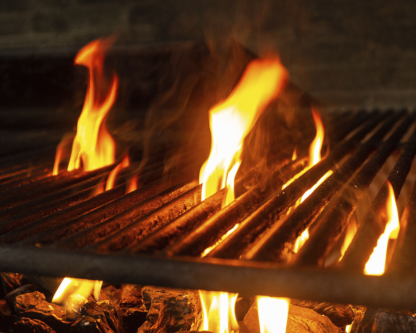 Brasas encendidas en la parrilla de Con Acento